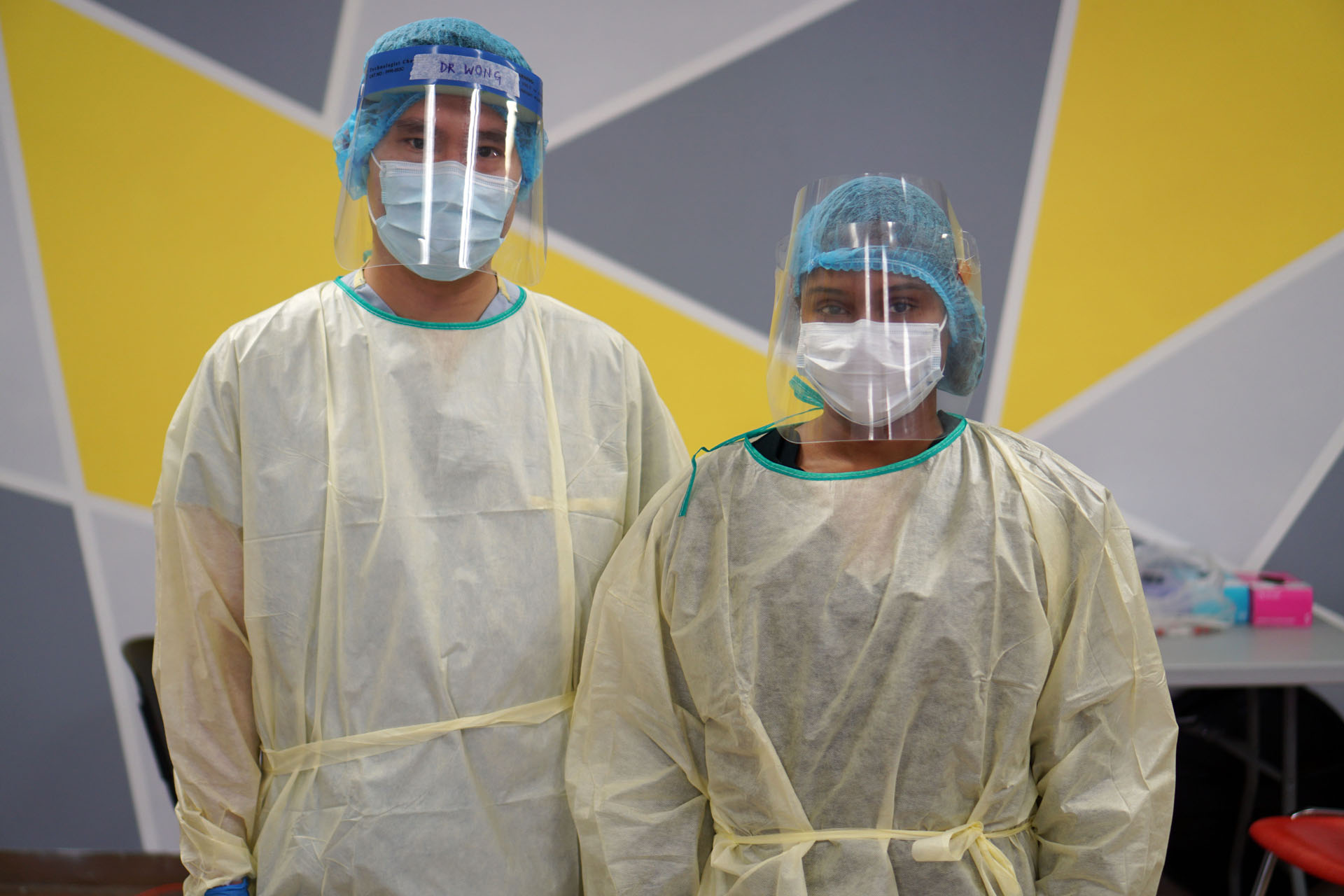 Two healthcare workers wearing masks and face shields