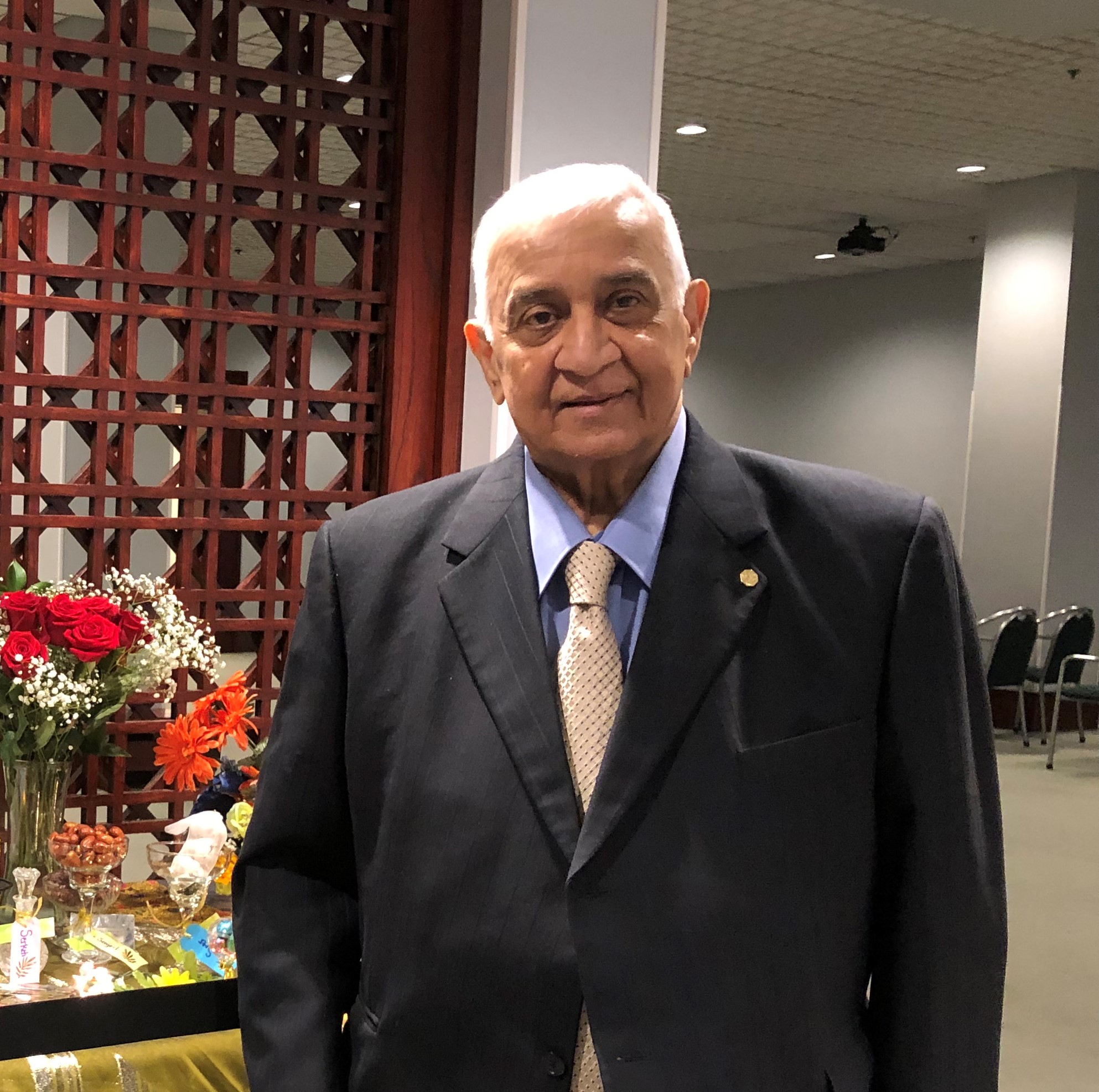 Nizar Hooda wearing a suit and smiling