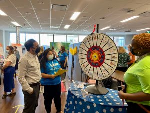 Jason Altenberg, CEO at South Riverdale Community Health Centre, spins the wheel at the ETHP Fair, which tests attendees’ knowledge of projects on display.