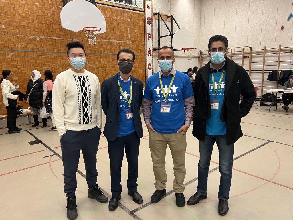 Four people with masks standing in gym.