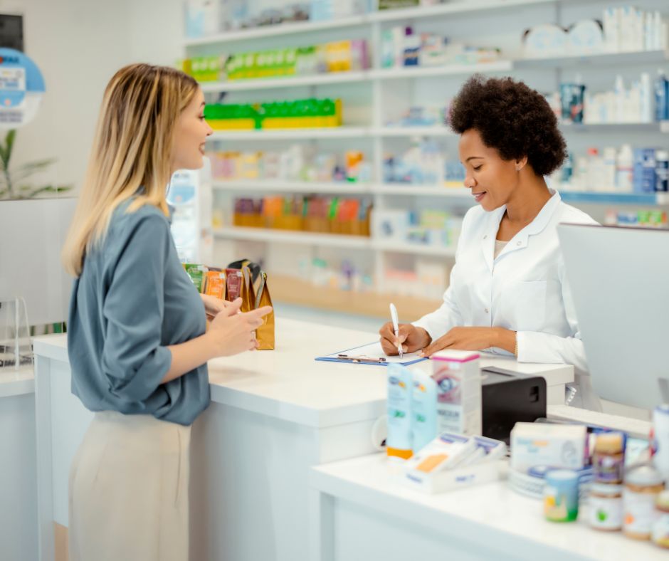 Person at the counter of a pharmacy speaking with pharmacist. 