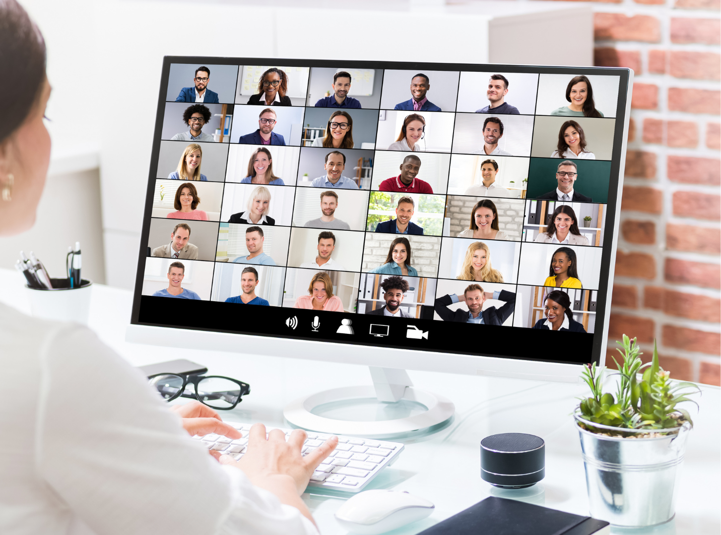 A person sits in front of a computer on a virtual call.